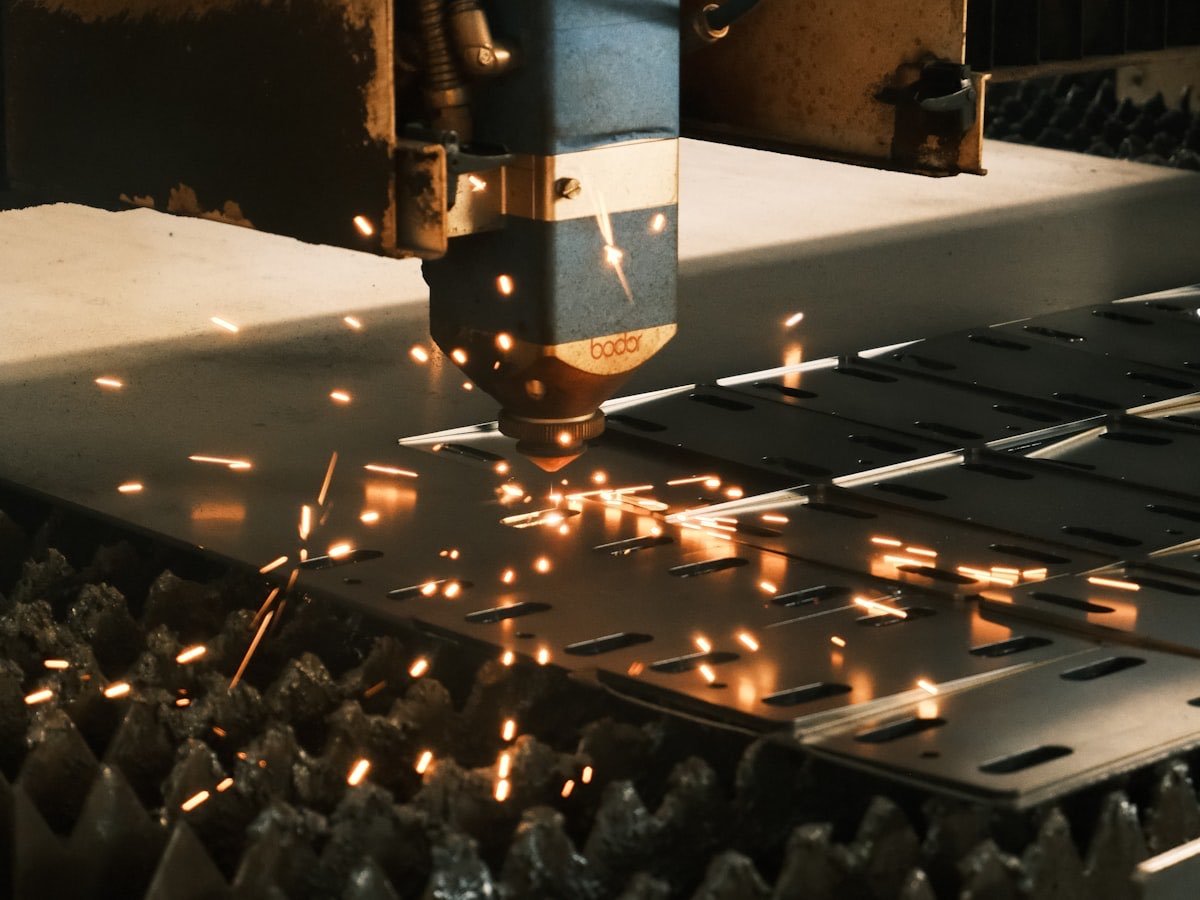 A laser cutter shaping steel on a factory floor