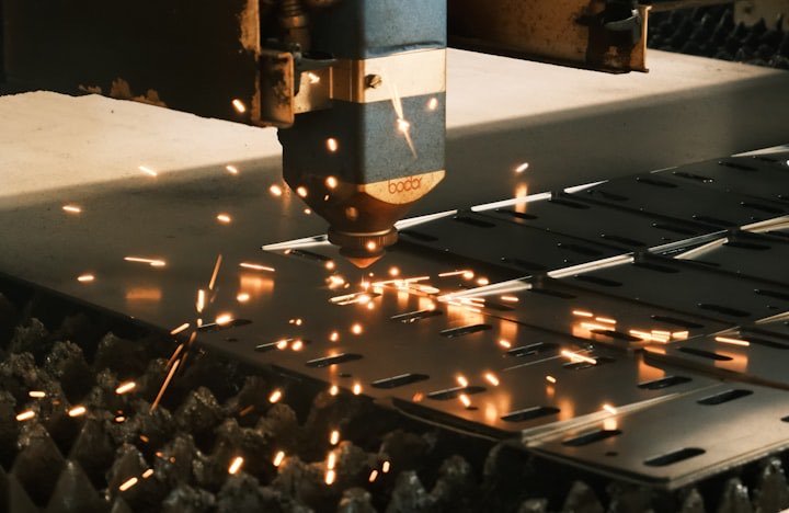 A laser cutter shaping steel on a factory floor